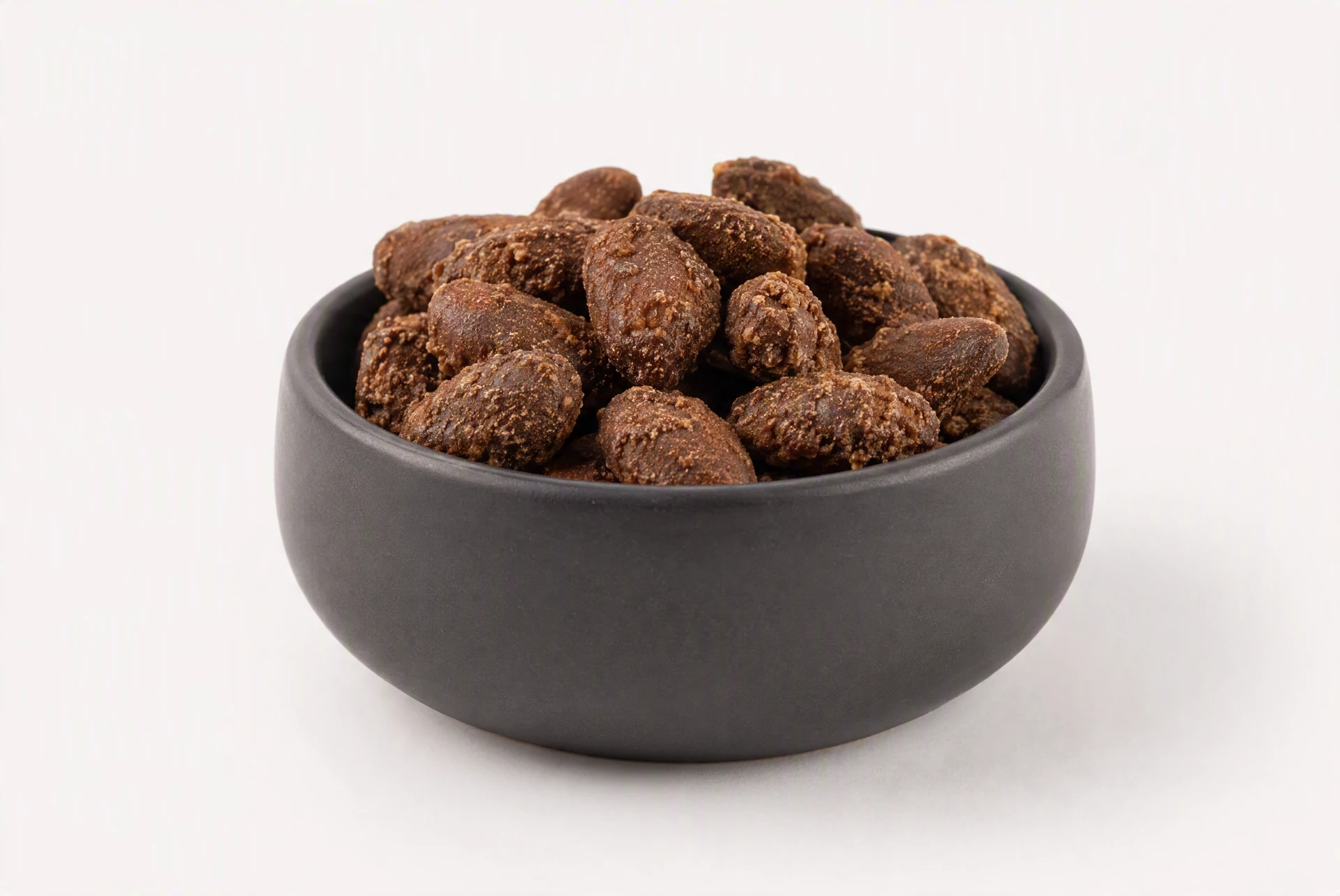 Roasted cacao beans in a dark bowl